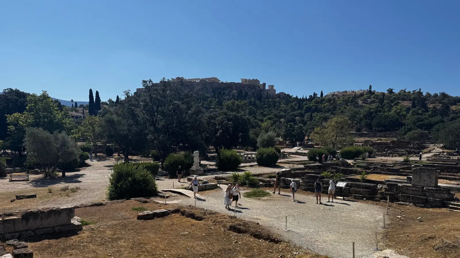 Η Αρχαία Αγορά στο πρώτο πλάνο και η Ακρόπολη με τον Παρθενώνα στον ορίζοντα από πάνω.
